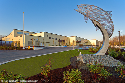 A view of the hatchery from the outside with a fish statue in the foreground